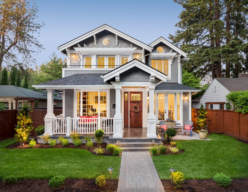 Beautiful gray and white craftsman style home with a large front yard.